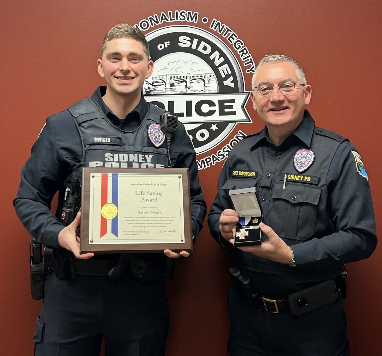 Officer Swiger holding Lifesaving Awards
